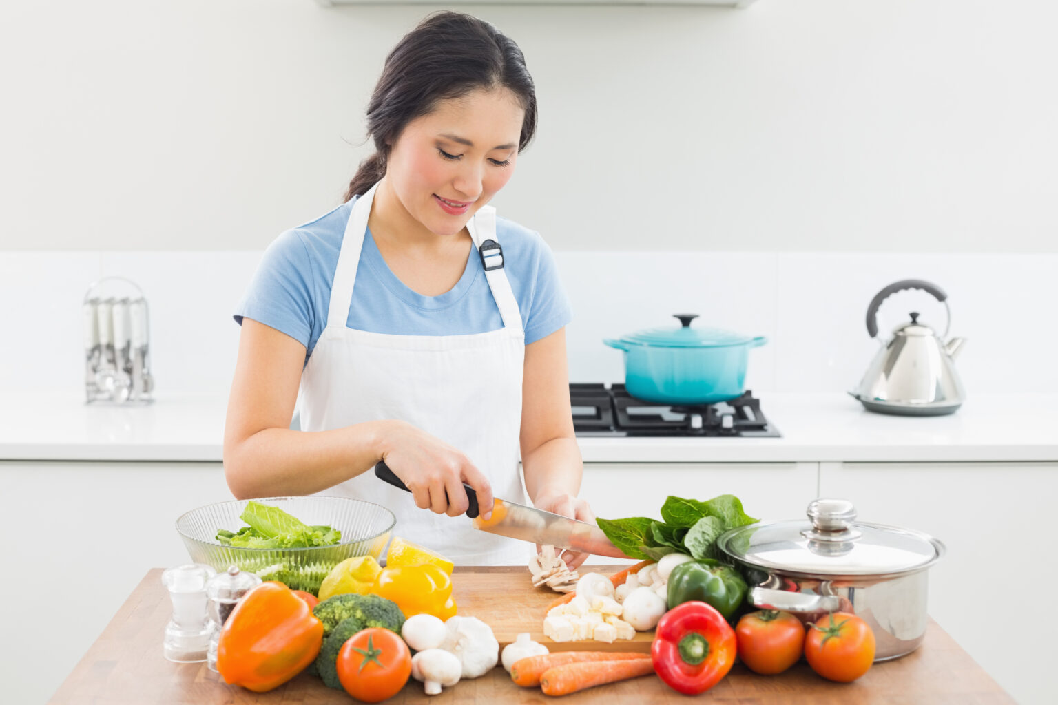 Smiling,Young,Woman,Chopping,Vegetables,In,The,Kitchen,At,Home